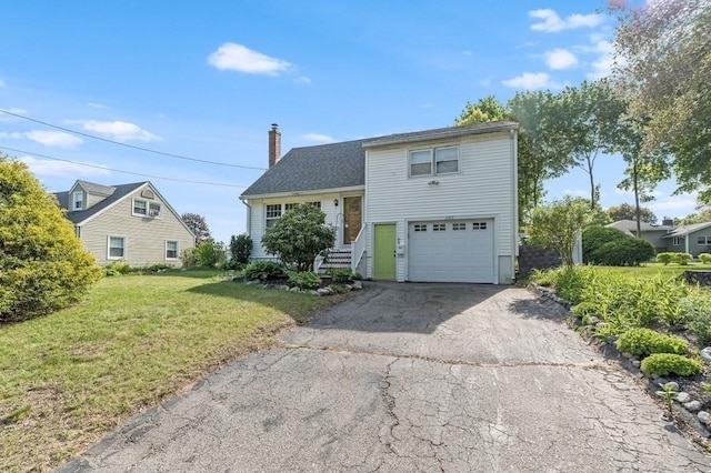 view of front facade with driveway, a front yard, a chimney, and a garage