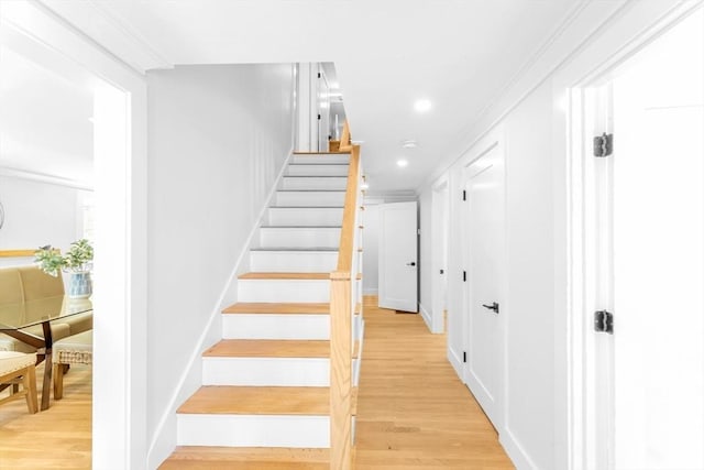 staircase featuring recessed lighting, ornamental molding, and wood finished floors