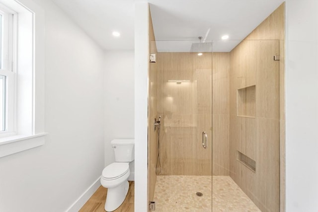 bathroom with toilet, recessed lighting, baseboards, wood finished floors, and a stall shower