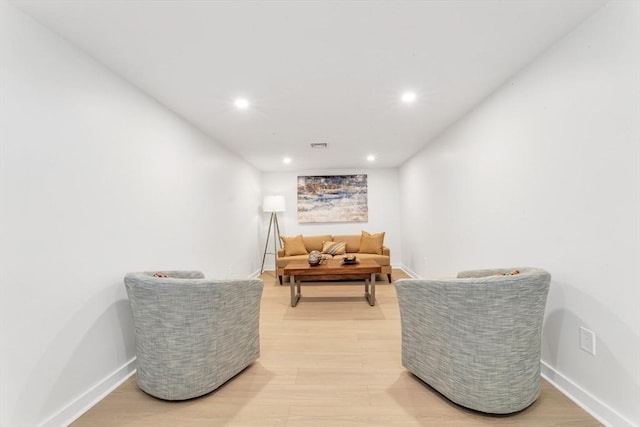 sitting room with baseboards, light wood-type flooring, and recessed lighting