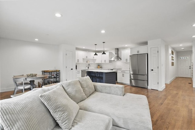 living room featuring baseboards, wood finished floors, and recessed lighting