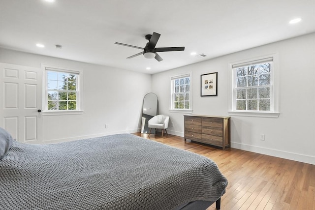 bedroom featuring recessed lighting, multiple windows, baseboards, and wood finished floors