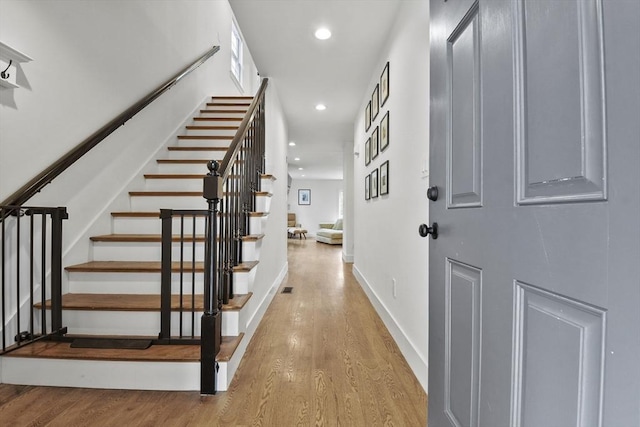 foyer with stairs, baseboards, wood finished floors, and recessed lighting