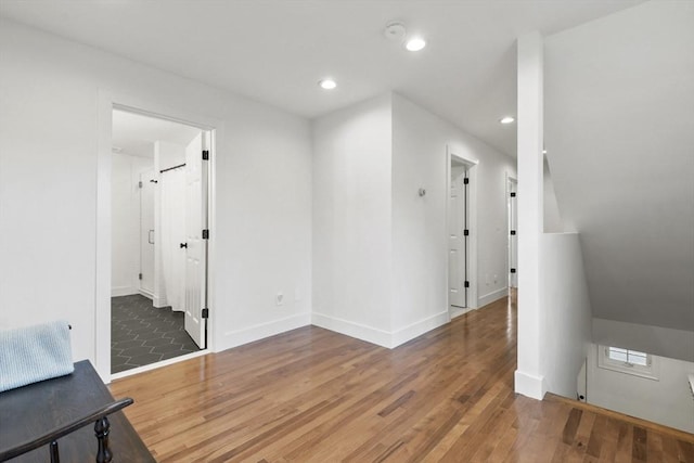 additional living space featuring baseboards, wood finished floors, and recessed lighting