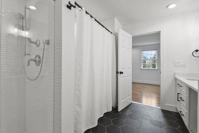 full bathroom with baseboards, a shower stall, vanity, and tile patterned floors