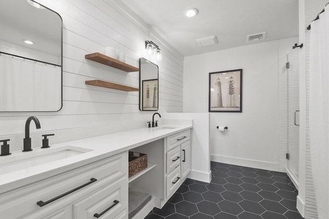 full bathroom with double vanity, a shower with shower curtain, a sink, and visible vents