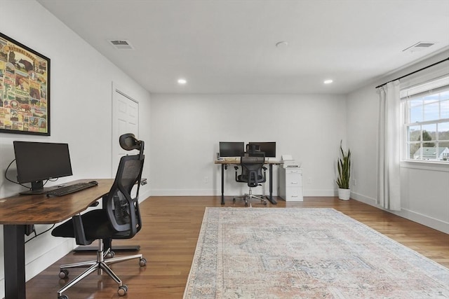 office area featuring visible vents, baseboards, and wood finished floors