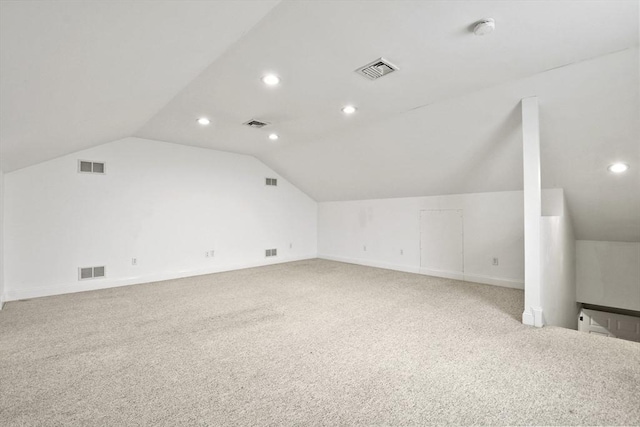 additional living space with vaulted ceiling, carpet floors, and visible vents