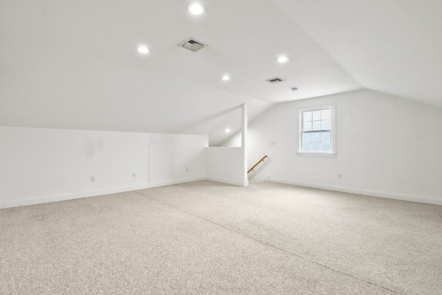 additional living space with baseboards, visible vents, vaulted ceiling, and recessed lighting