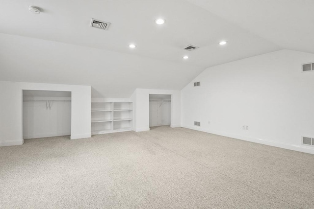 additional living space with recessed lighting, visible vents, vaulted ceiling, and light colored carpet