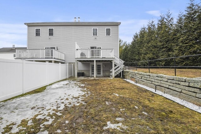 back of property featuring a deck, french doors, stairway, and fence