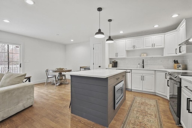 kitchen featuring open shelves, decorative backsplash, stainless steel appliances, and light countertops