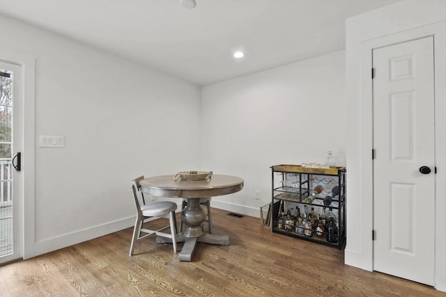 dining space featuring visible vents, baseboards, wood finished floors, and recessed lighting