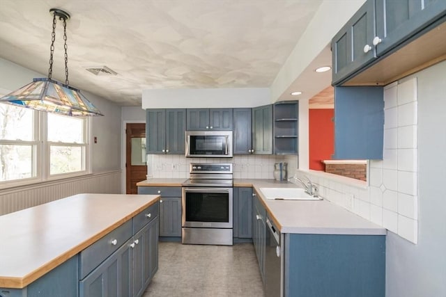 kitchen featuring visible vents, open shelves, light countertops, a sink, and stainless steel appliances