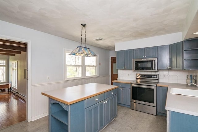 kitchen with open shelves, light countertops, a sink, appliances with stainless steel finishes, and blue cabinetry