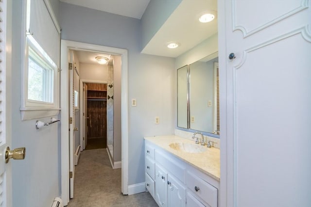 bathroom featuring a stall shower, baseboards, and vanity