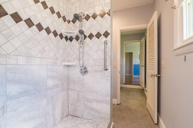 full bath with baseboards and tiled shower