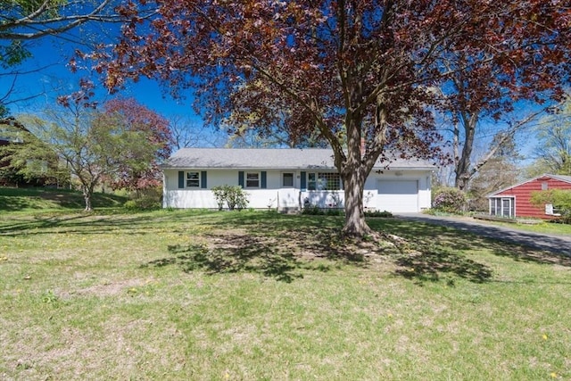 view of front of property featuring a garage, a front lawn, and aphalt driveway