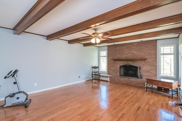 unfurnished living room with a brick fireplace, baseboards, light wood-type flooring, beamed ceiling, and a baseboard heating unit