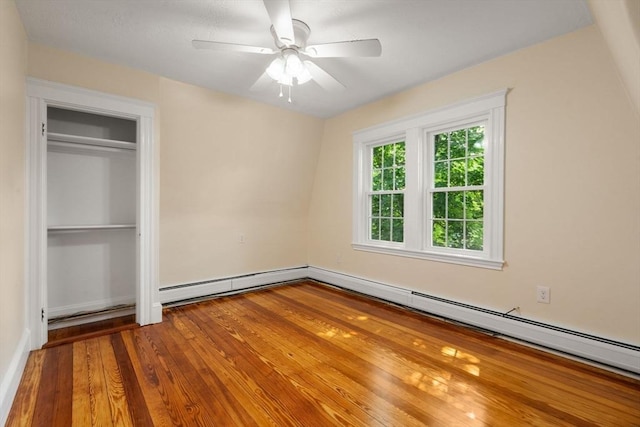 14 E Division St, Holbrook, MA 02343 - unfurnished bedroom featuring wood finished floors, baseboard heating, a baseboard radiator, a closet, and ceiling fan