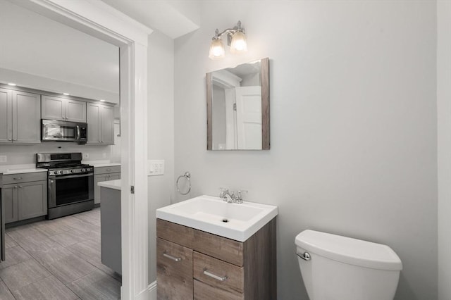 14 E Division St, Holbrook, MA 02343 - bathroom featuring vanity, toilet, and wood finished floors