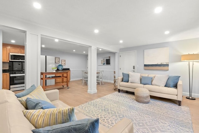 living room featuring crown molding and light wood-type flooring