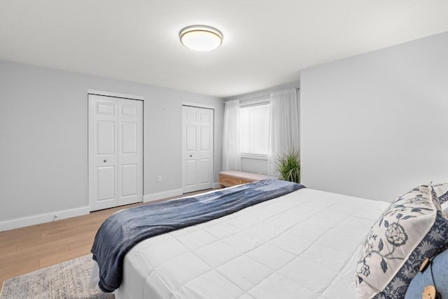 bedroom featuring hardwood / wood-style flooring and two closets