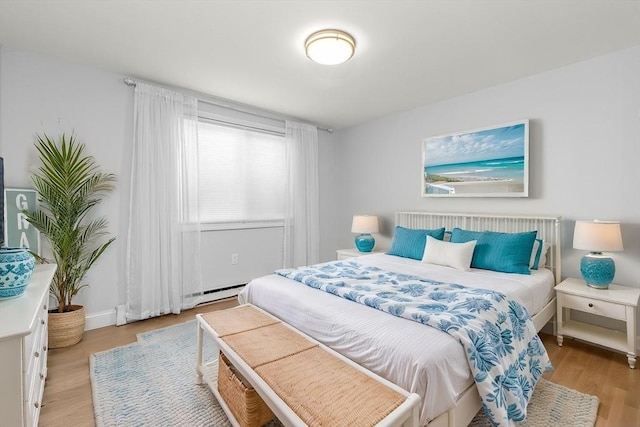 bedroom featuring a baseboard radiator and light hardwood / wood-style flooring