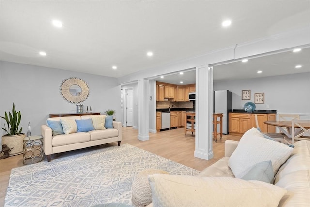 living room featuring decorative columns and light wood-type flooring