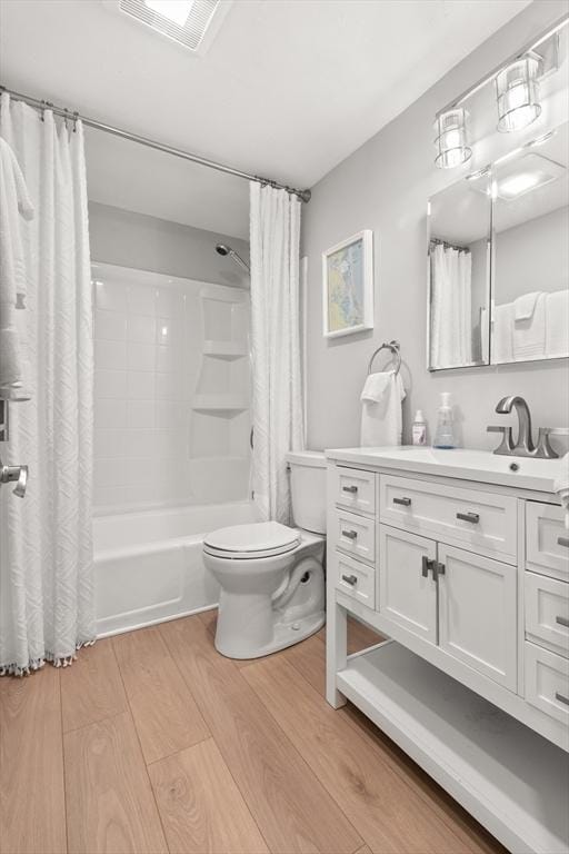 full bathroom featuring shower / bath combination with curtain, vanity, toilet, and hardwood / wood-style flooring