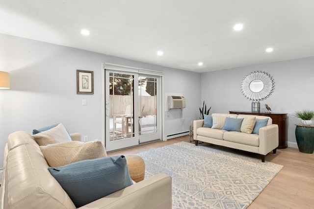 living room featuring a wall unit AC, baseboard heating, and light hardwood / wood-style floors