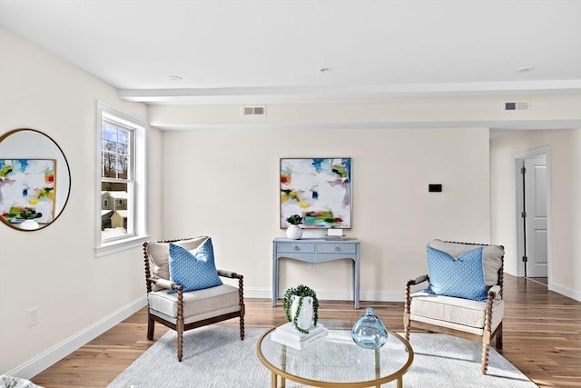 sitting room featuring visible vents, baseboards, and wood finished floors