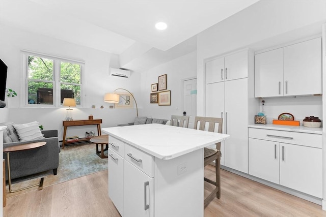 2A Brewer St, Boston, MA 02130 - kitchen featuring light wood finished floors, a kitchen bar, open floor plan, white cabinetry, and a kitchen island
