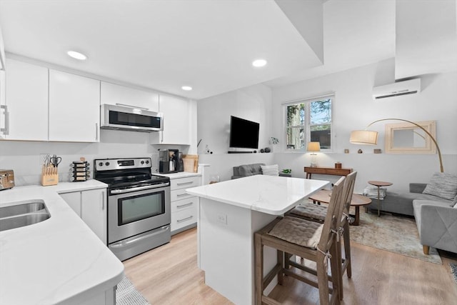 2A Brewer St, Boston, MA 02130 - kitchen featuring stainless steel appliances, open floor plan, a kitchen bar, a sink, and recessed lighting