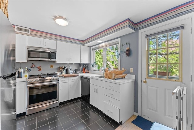 2A Brewer St, Boston, MA 02130 - kitchen featuring appliances with stainless steel finishes, light countertops, healthy amount of natural light, and white cabinetry