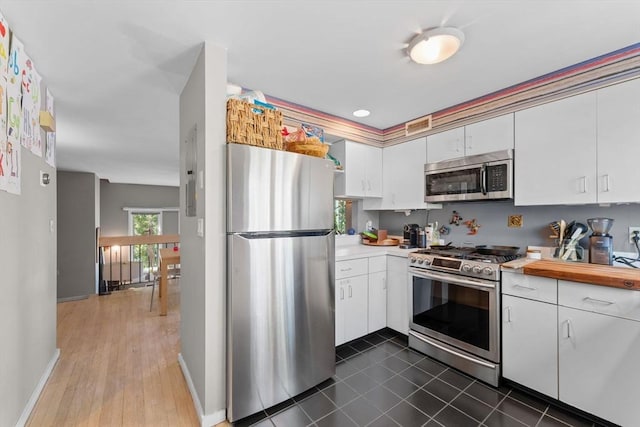 2A Brewer St, Boston, MA 02130 - kitchen with appliances with stainless steel finishes, white cabinetry, baseboards, and electric panel