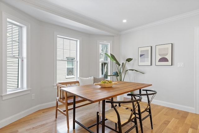 dining area with light hardwood / wood-style floors and ornamental molding