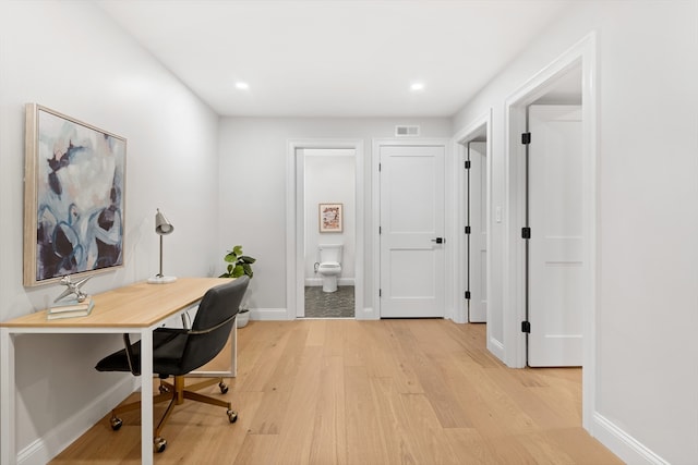 home office with light hardwood / wood-style floors