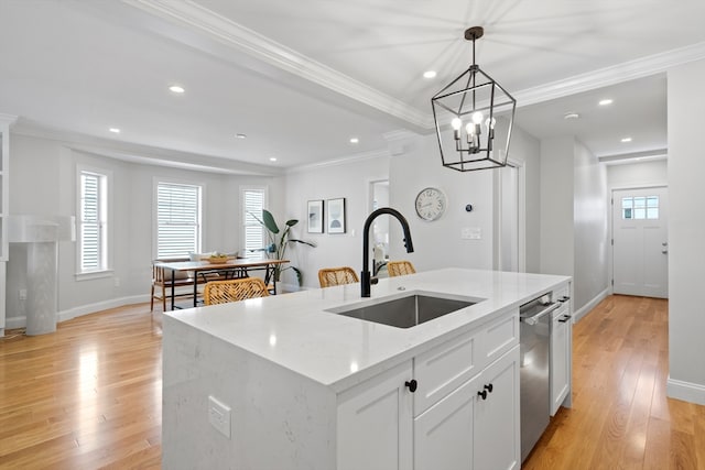 kitchen with white cabinetry, sink, light stone counters, light hardwood / wood-style floors, and a kitchen island with sink