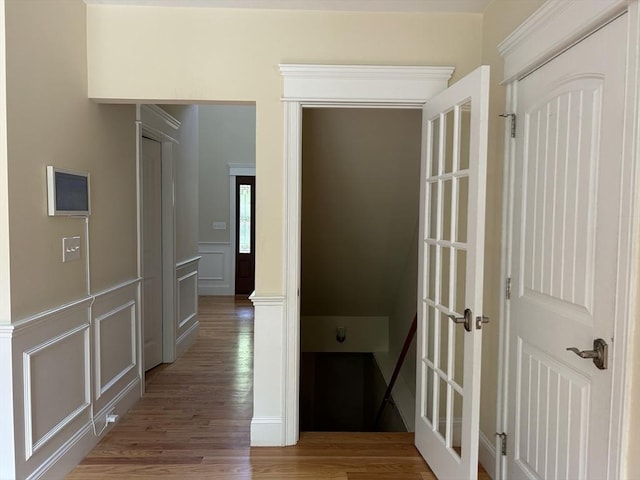 61 School St Unit B, Natick, MA 01760 - corridor featuring light wood finished floors, a decorative wall, and a wainscoted wall