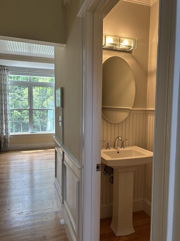 61 School St Unit B, Natick, MA 01760 - bathroom featuring wood finished floors, a wainscoted wall, and a decorative wall