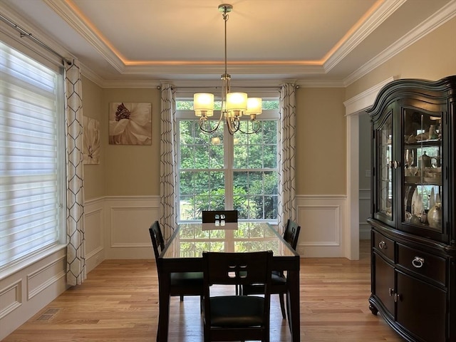 61 School St Unit B, Natick, MA 01760 - dining space with a chandelier, a decorative wall, a tray ceiling, light wood-style floors, and wainscoting