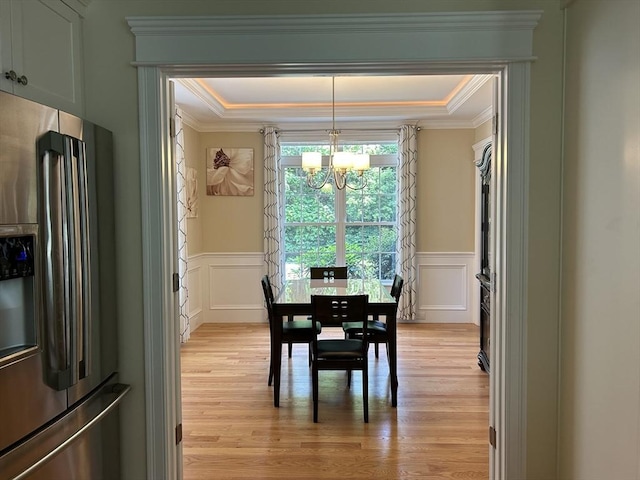 61 School St Unit B, Natick, MA 01760 - dining room featuring a chandelier, light wood-style floors, a decorative wall, crown molding, and a wainscoted wall