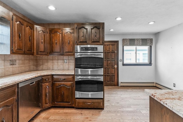 kitchen with stainless steel appliances, light wood-type flooring, light stone countertops, tasteful backsplash, and recessed lighting