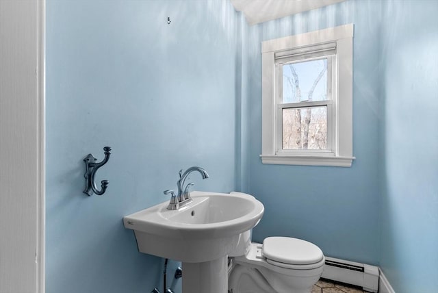 half bathroom with toilet, baseboards, and baseboard heating