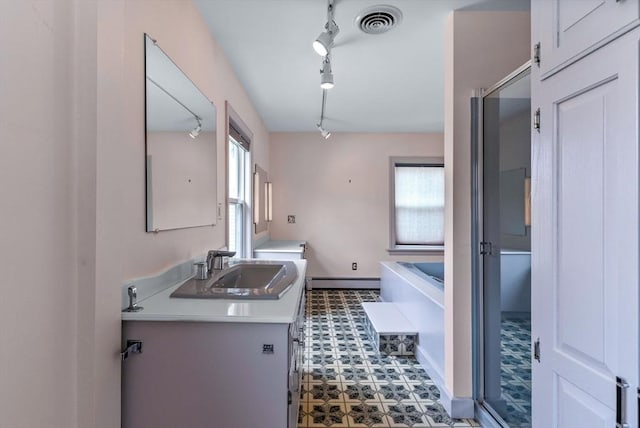 interior space featuring a baseboard radiator, visible vents, tile patterned floors, vanity, and a tub