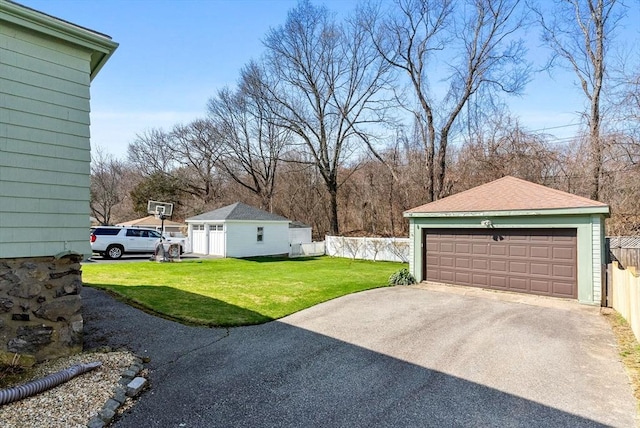 view of yard featuring an outbuilding, fence, and a detached garage