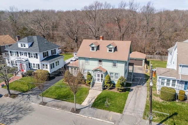view of front of house featuring fence, a chimney, a view of trees, and a front yard
