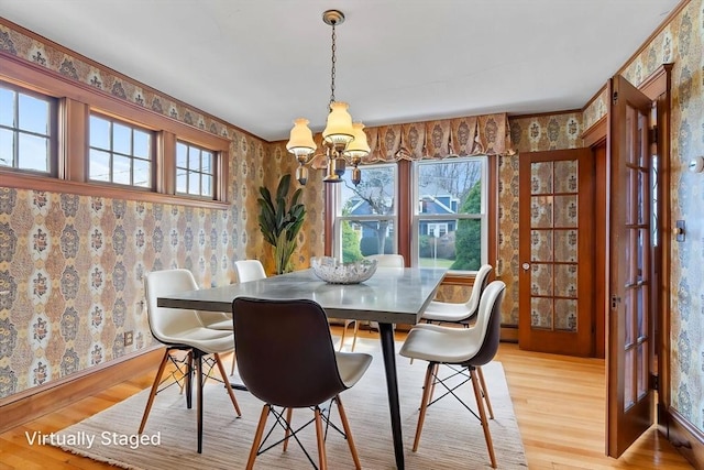 dining space with baseboards, a notable chandelier, light wood-type flooring, and wallpapered walls