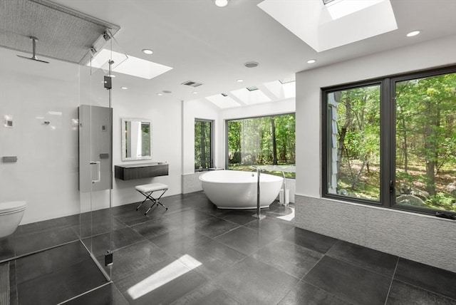 169 Hickory Rd, Weston, MA 02493 - bathroom with a skylight, a freestanding tub, a stall shower, toilet, and recessed lighting